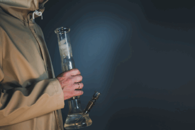 A person holding a glass bong