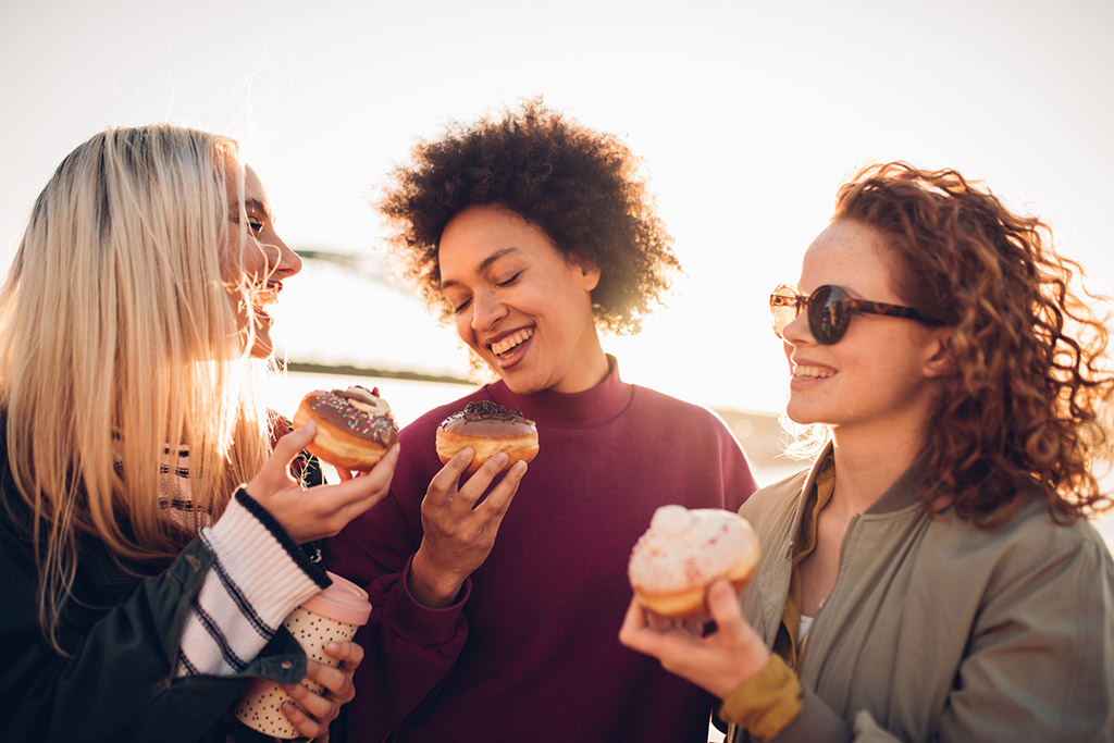 three friends eat doughnuts after a smoking sesh
