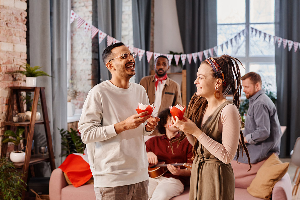  a group of friends at a party and two people eating cupcakes
