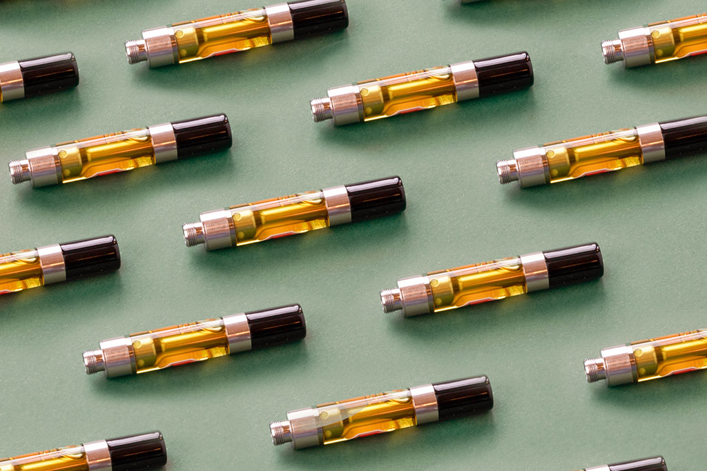 a flatlay of a series of vapes on a green background