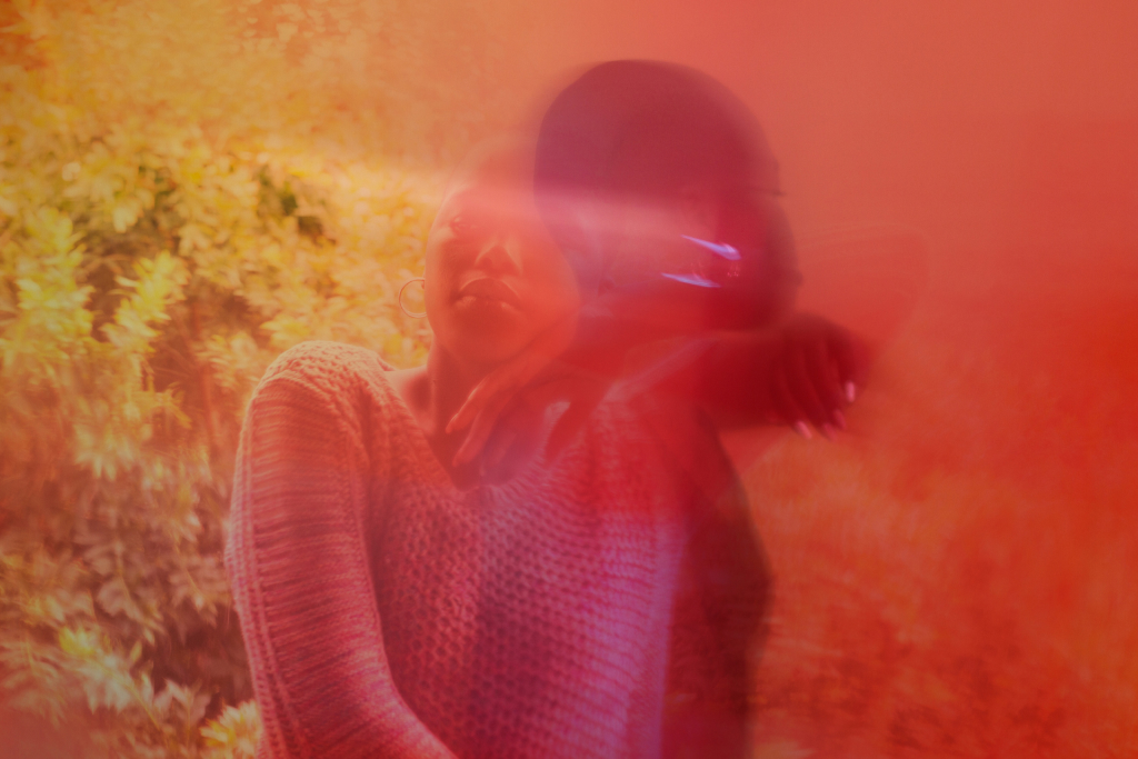a trippy yellow and red hued image of a woman turning away from the camera