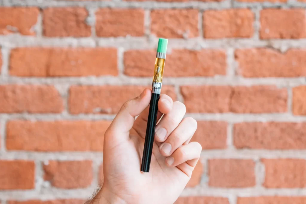 A hand holding a vape