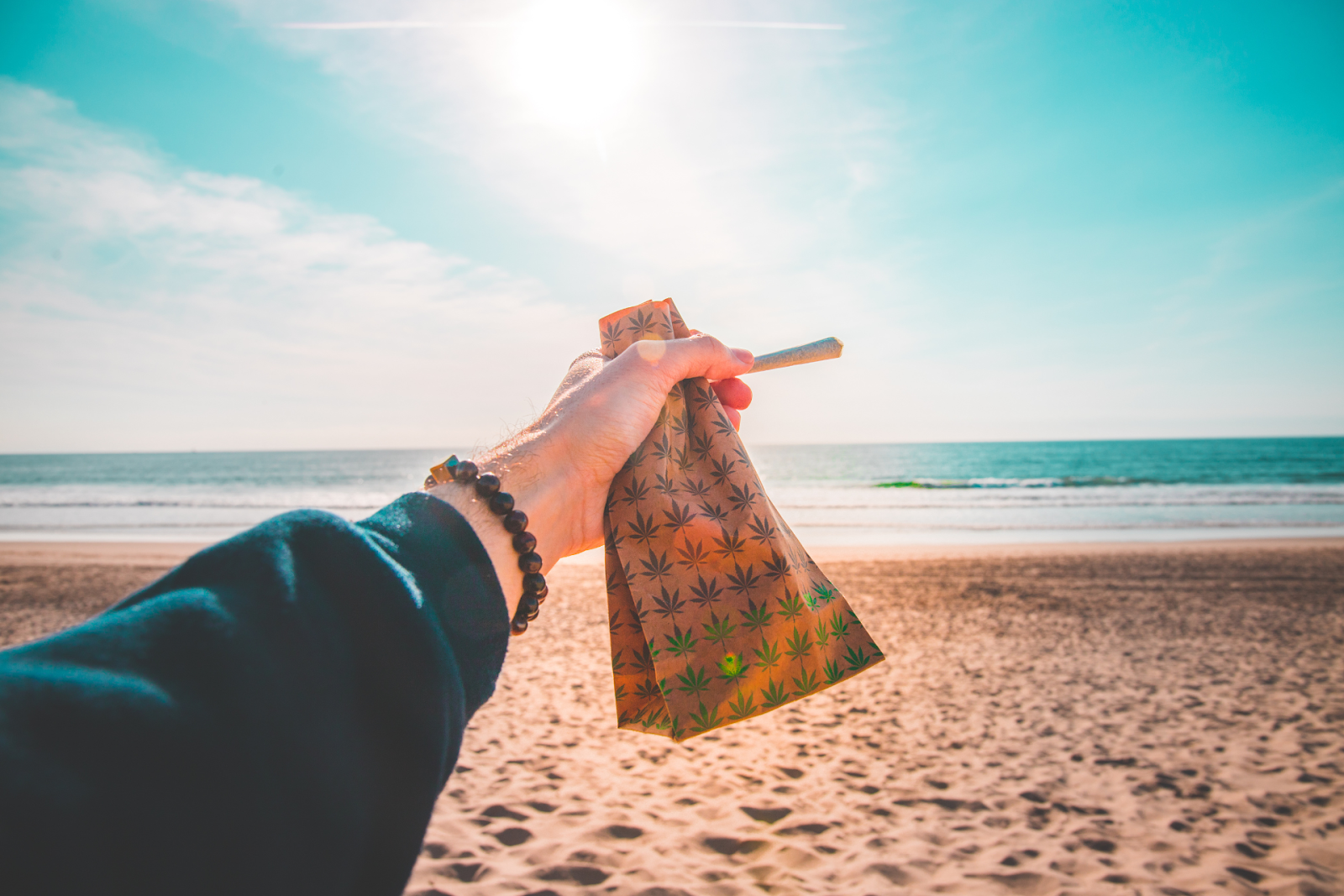 A man holding a joint and bag of cannabis while on a road trip in Ontario