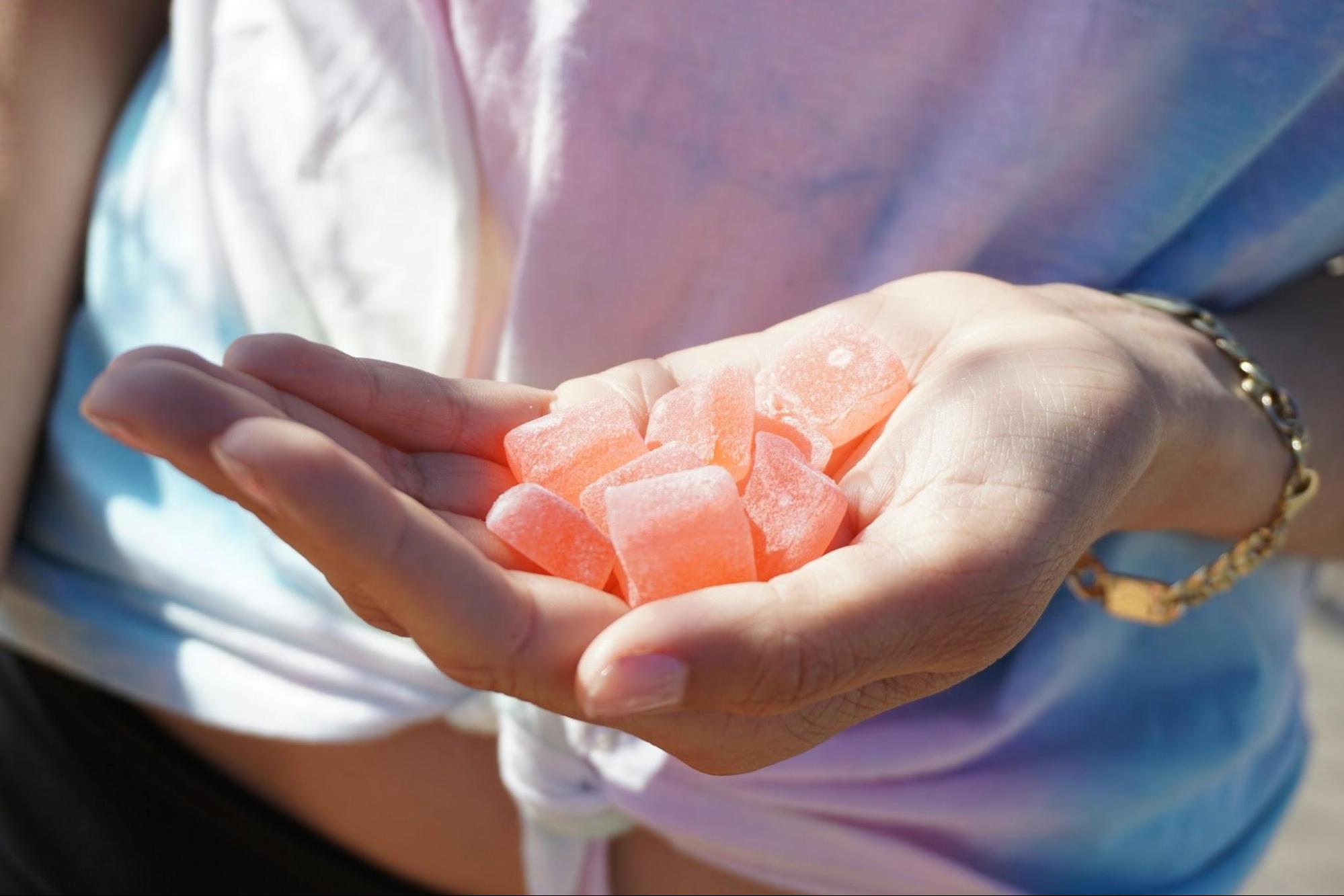 A woman holding a handful of cannabis edibles
