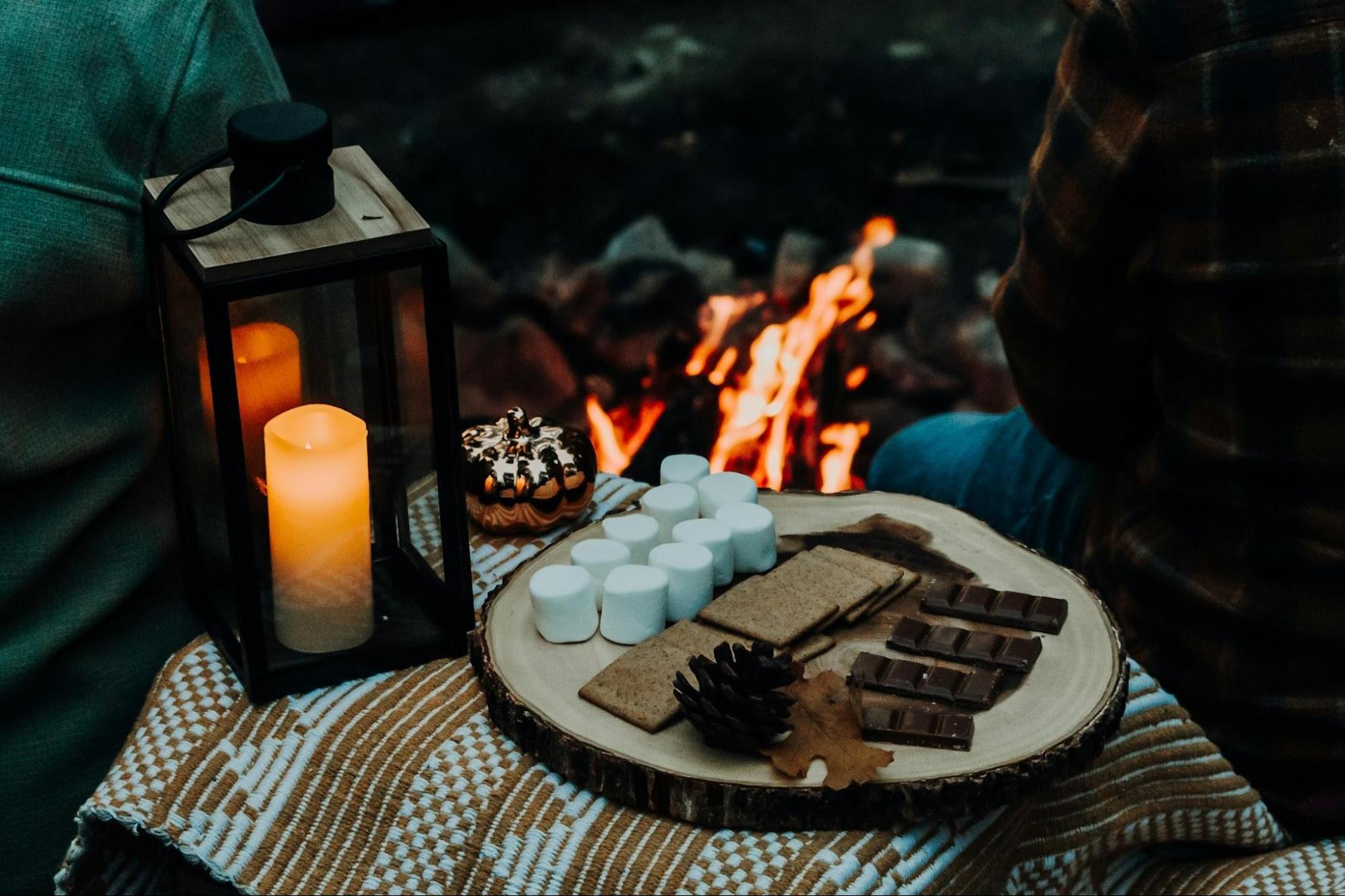 A plate with S’mores next to a campfire