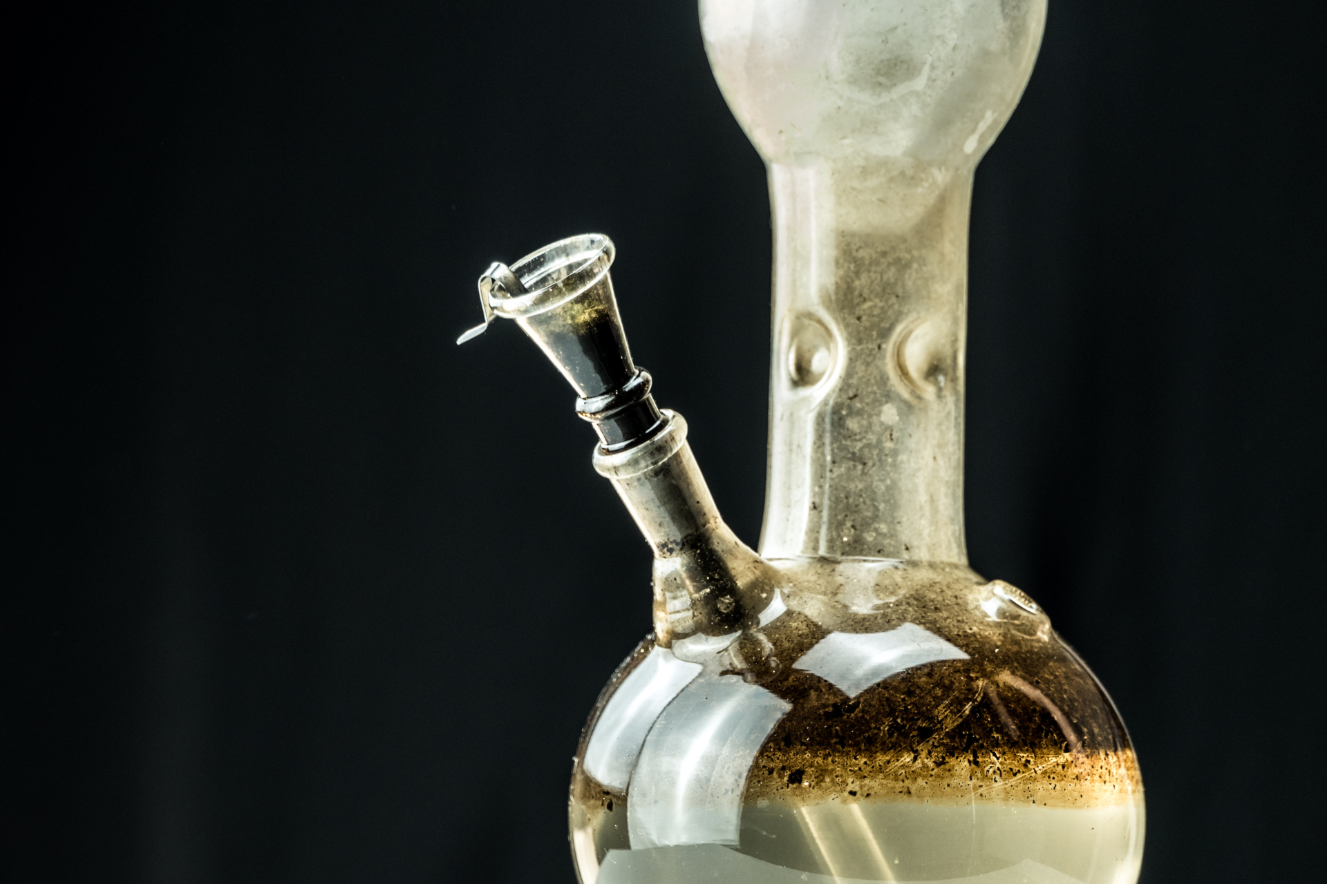 A used bong with dirty bong water containing burnt plant particles