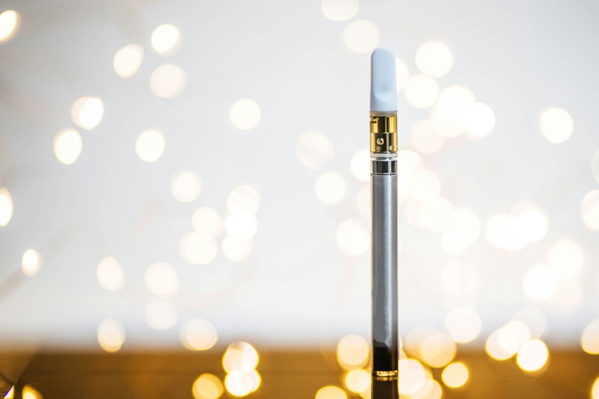 A vape pen with a THC cart, standing upright