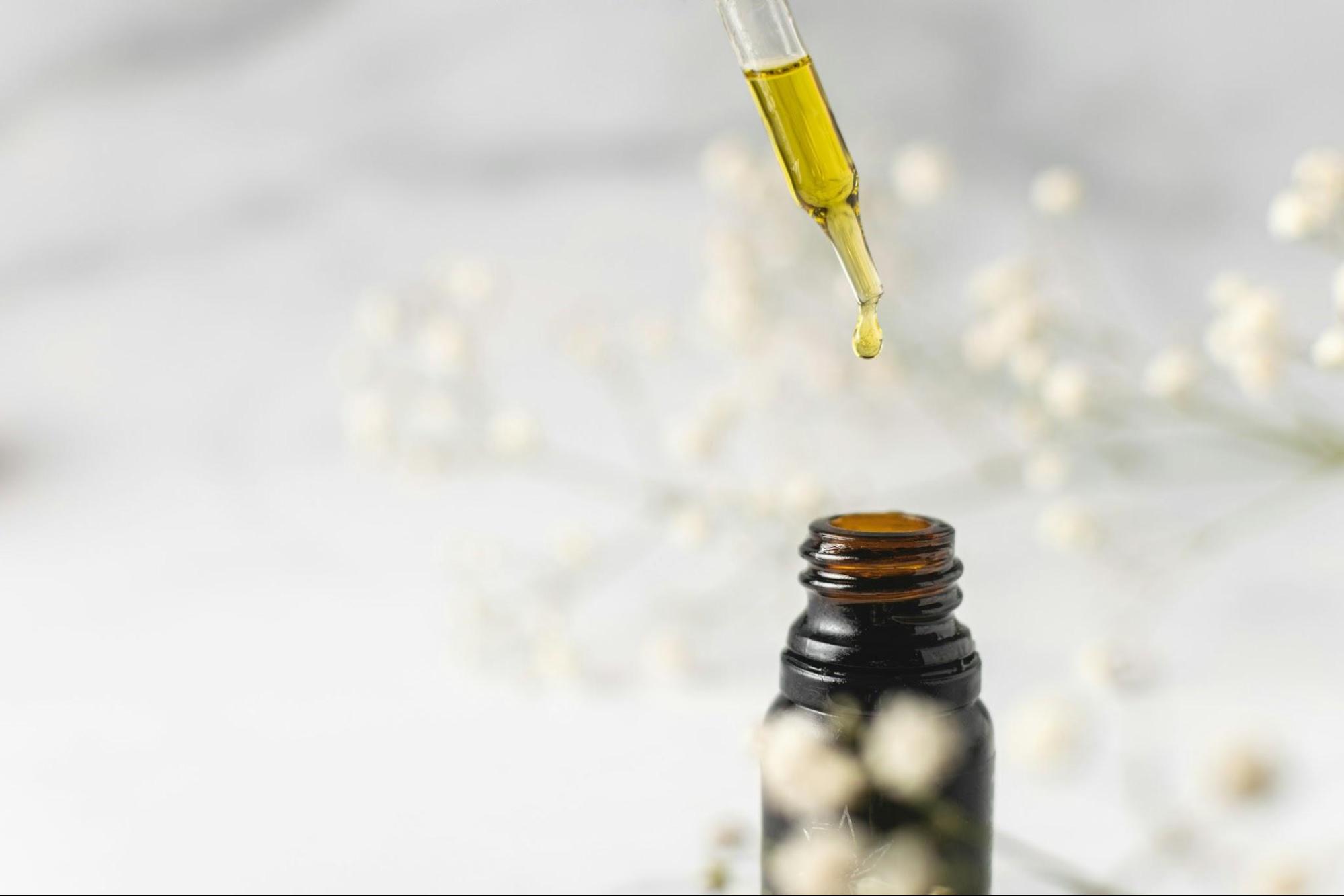 A glass dropper with a Cannabis Oil dripping out