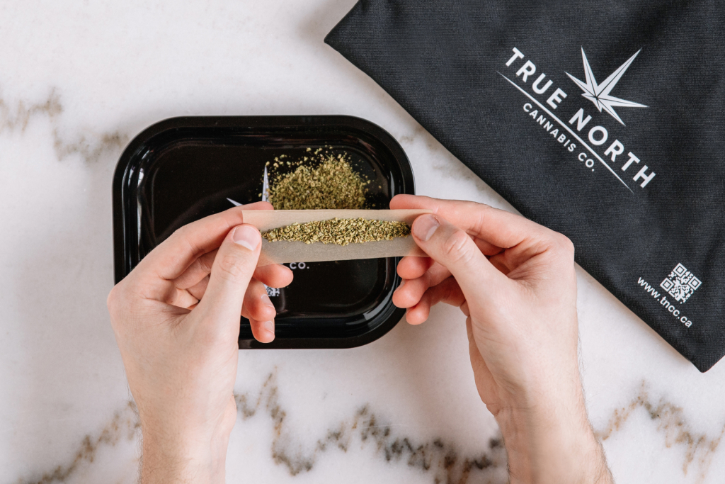 A person rolling a joint on a True North Cannabis Co. rolling tray