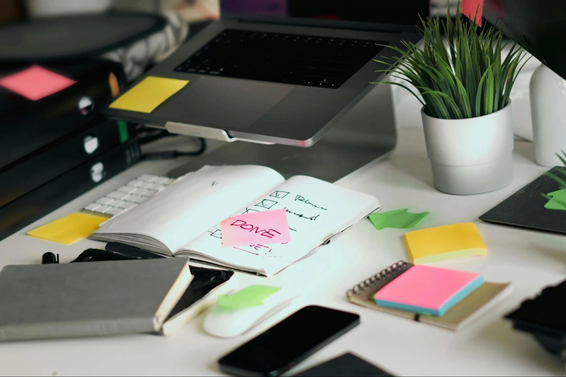 Desk with laptop and checklist notepad in a bright workspace